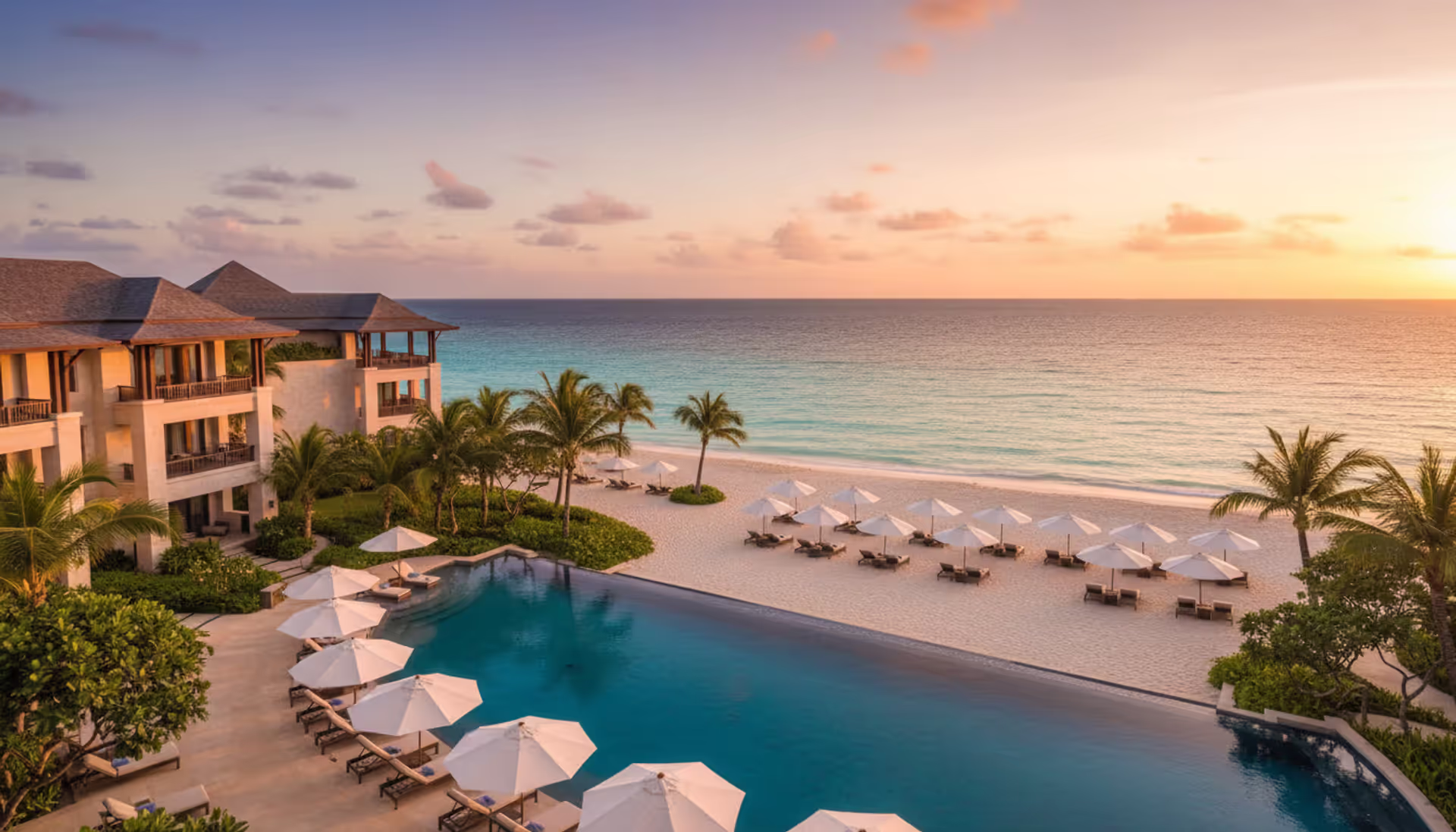 Luxury beachfront all-inclusive resort with infinity pool overlooking turquoise ocean at golden hour