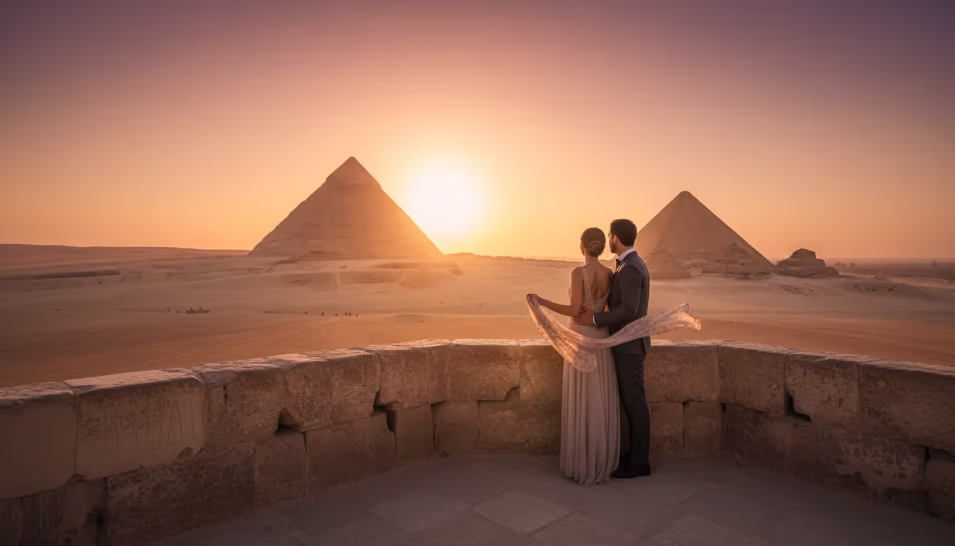 Elegant couple admiring the Giza Pyramids at golden sunset from a luxury viewpoint terrace